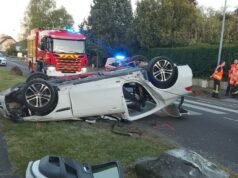 sebuah mobil di atap, dua penumpangnya keluar